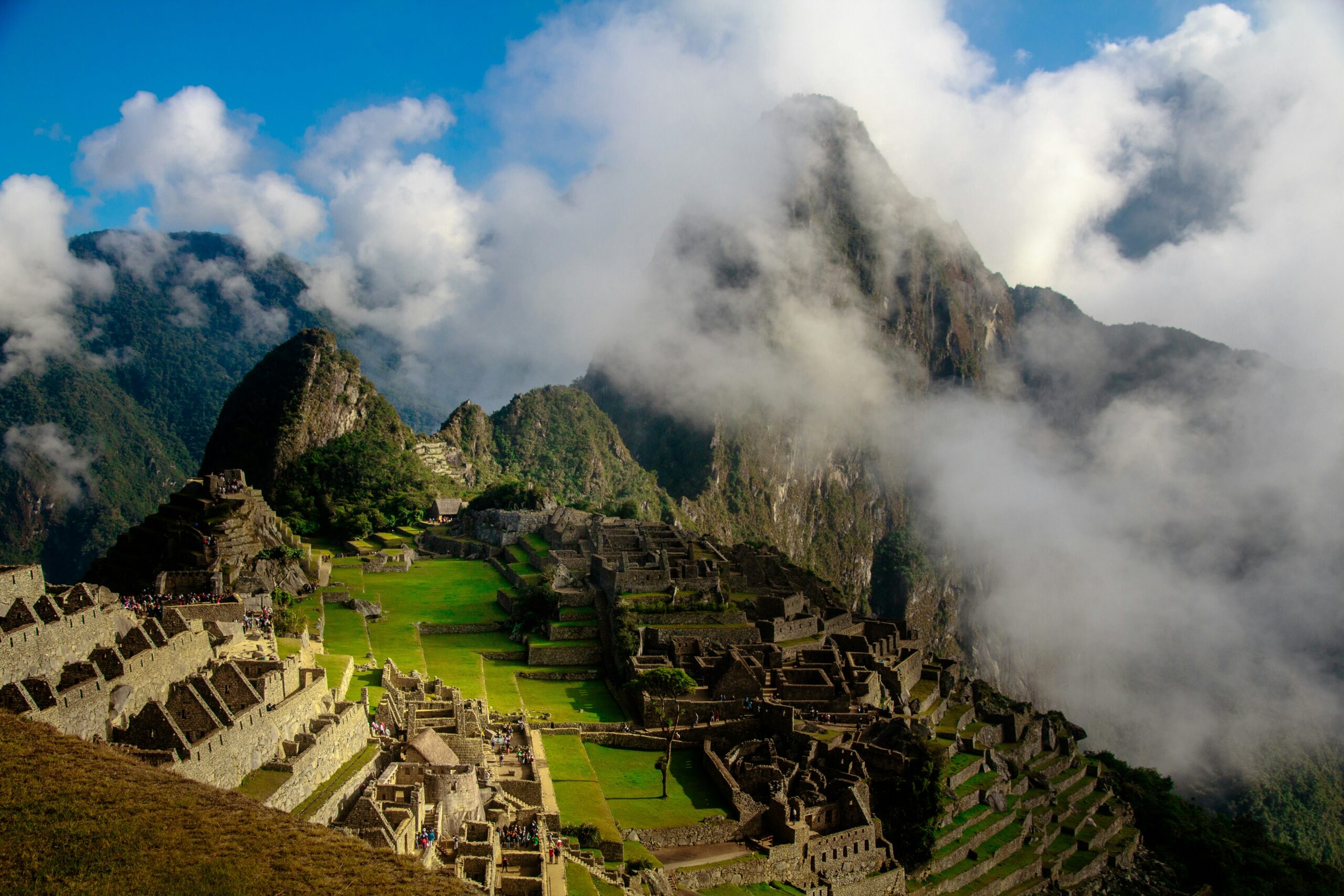 Ancient Incan ruins of Machu Picchu on a green mountain ridge during sunrise