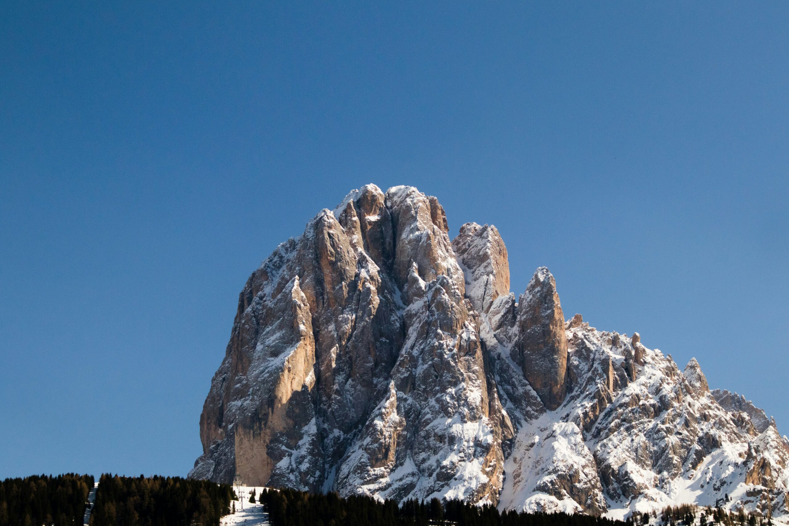 Sharp jagged limestone mountain peaks of the Dolomites under a colorful sunset sky