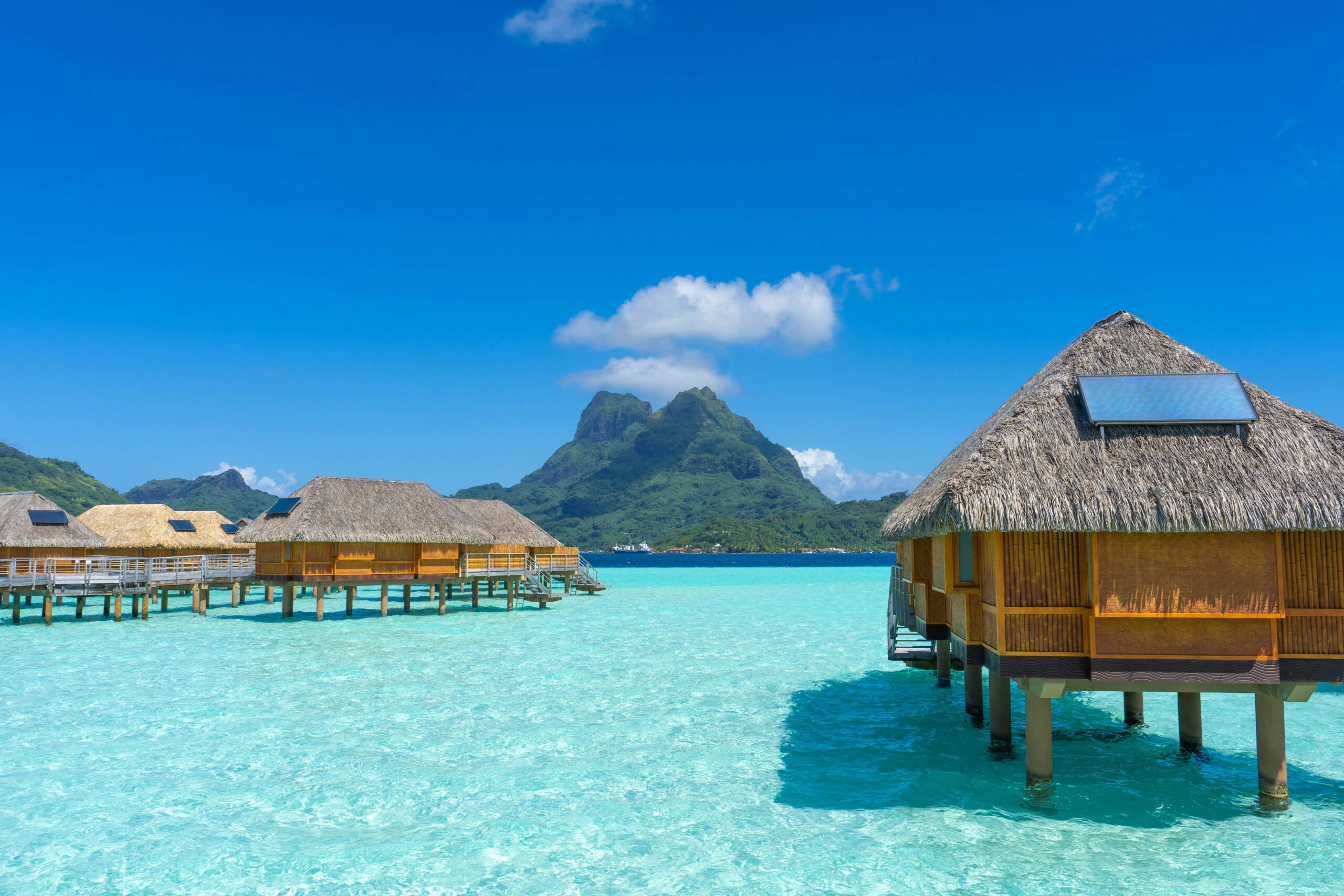 Luxury overwater bungalows extending into the clear turquoise lagoon of Bora Bora
